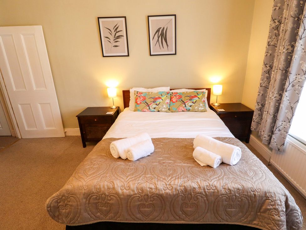 A bedroom with a bed and bedside tables at Maples in Hunstanton