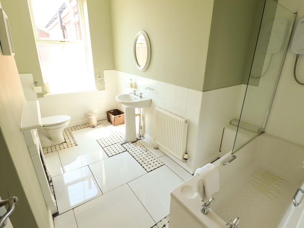 A bathroom with a sink, toilet, bathtub and shower at Maples in Hunstanton