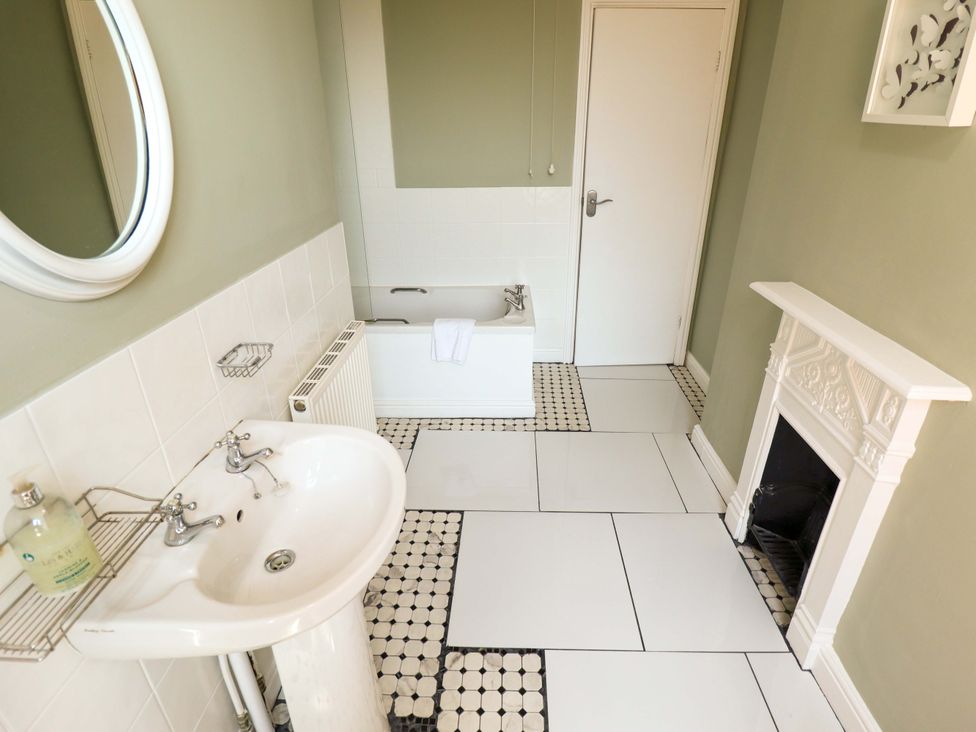 A bathroom with a bathtub and sink at Maples in Hunstanton