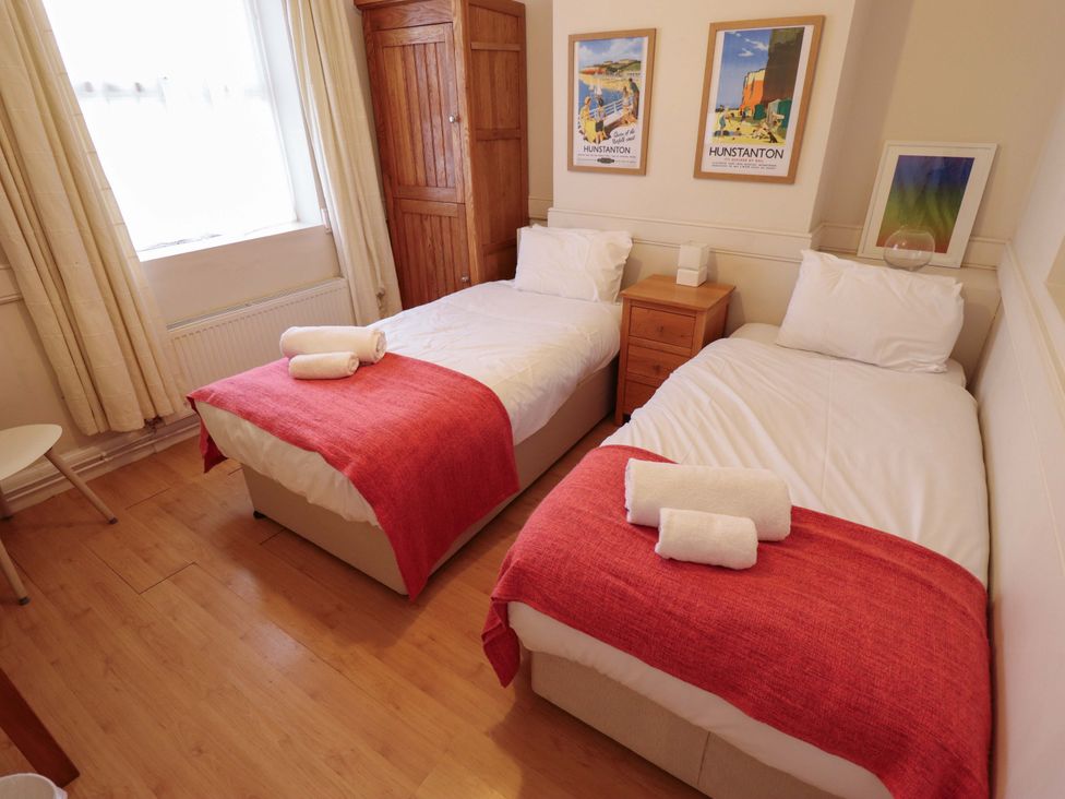 A bedroom with two beds and a nightstand at Maples Hunstanton