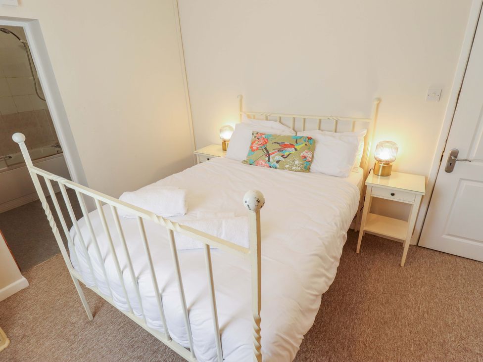 A bedroom with a bed and bedside table at Maples in Hunstanton