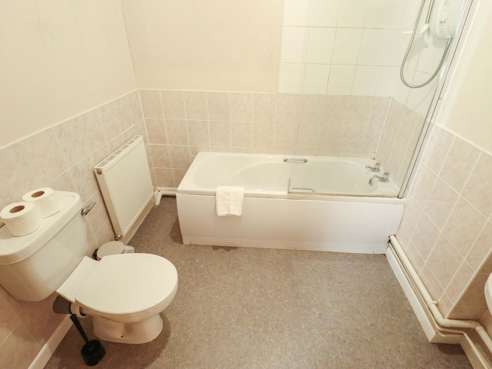 A bathroom featuring a bathtub, toilet, and sink at Maples in Hunstanton