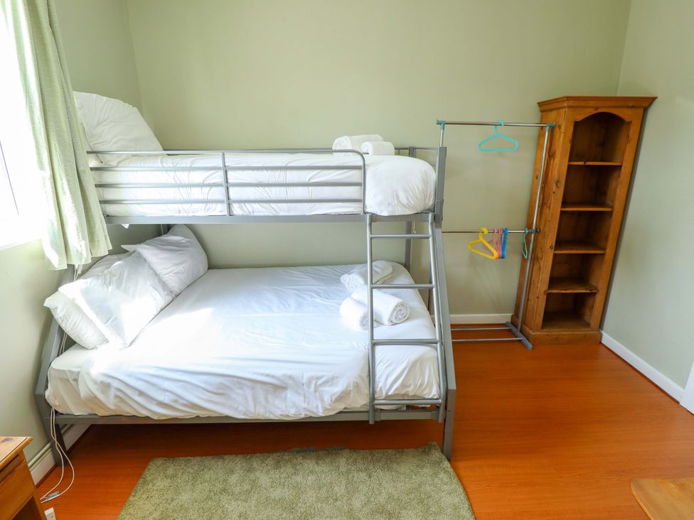 A bedroom with a bunk bed and a clothes rack at Maples in Hunstanton