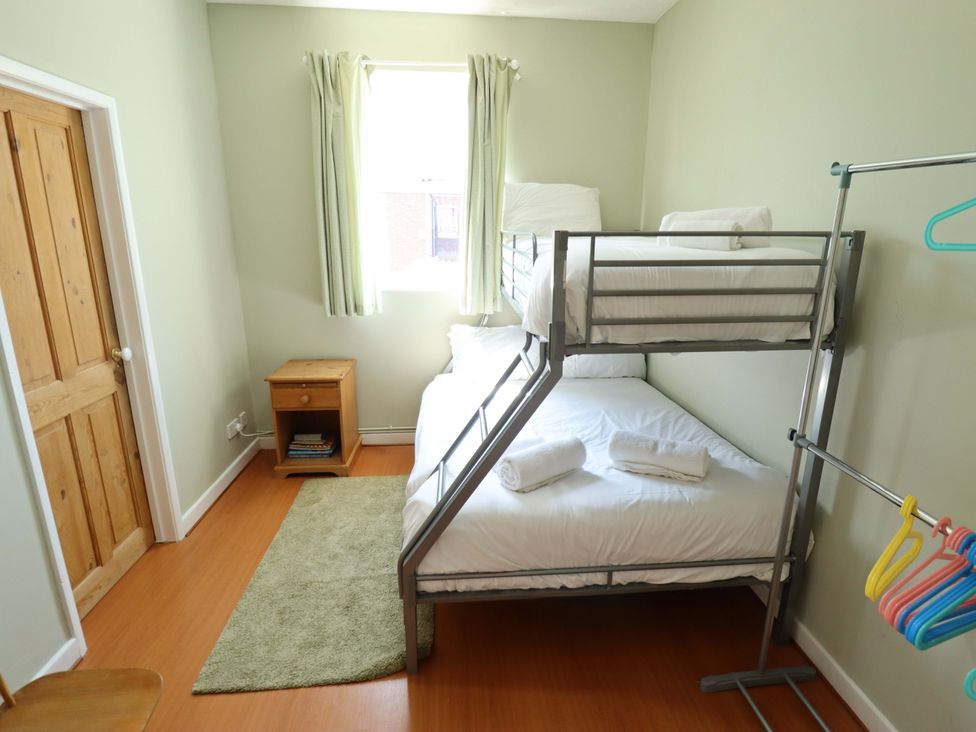 A bedroom with a bunk bed and a nightstand at Maples in Hunstanton