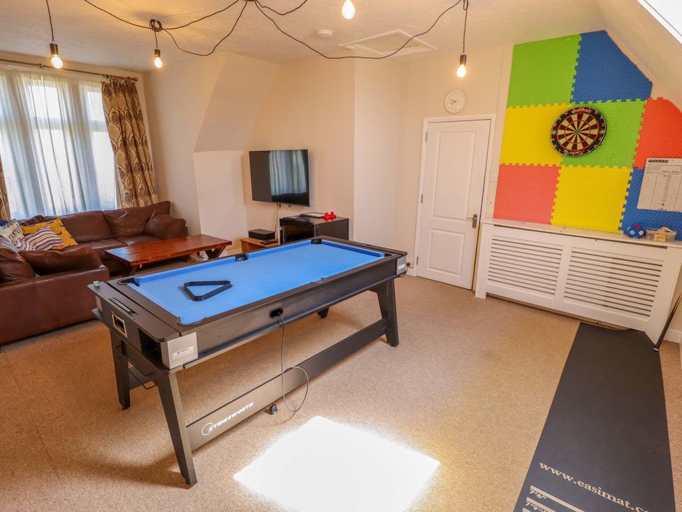 A game room with a pool table and dartboard at Maples in Hunstanton