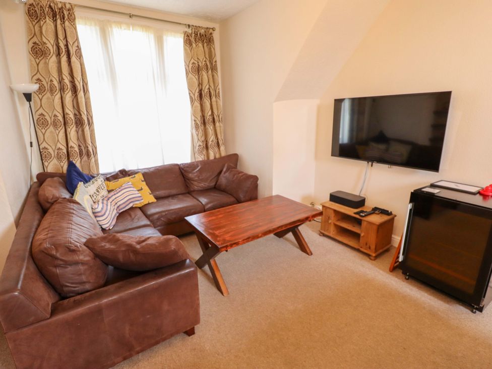 A living room with a sofa and television at Maples in Hunstanton