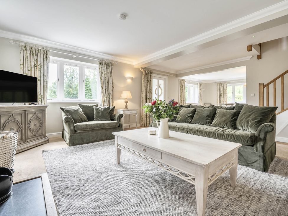 A living room with a sofa, coffee table, and television at Cunsey Lodge at the Graythwaite Estate