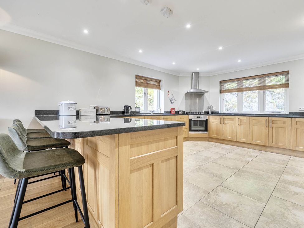 A kitchen with a countertop and stools at Cunsey Lodge at the Graythwaite Estate near Hawkshead