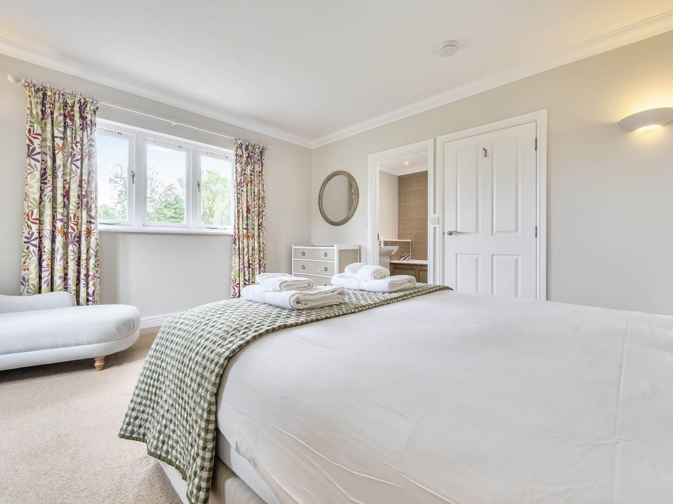 A bedroom with a bed and a dresser at Cunsey Lodge at the Graythwaite Estate