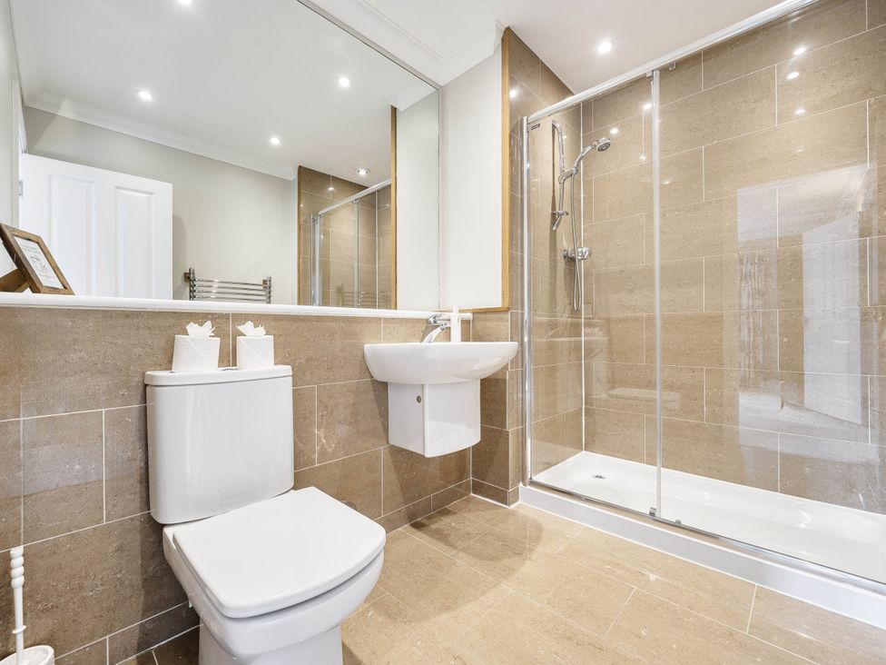 A bathroom with a toilet, washbasin, and shower at Cunsey Lodge at the Graythwaite Estate