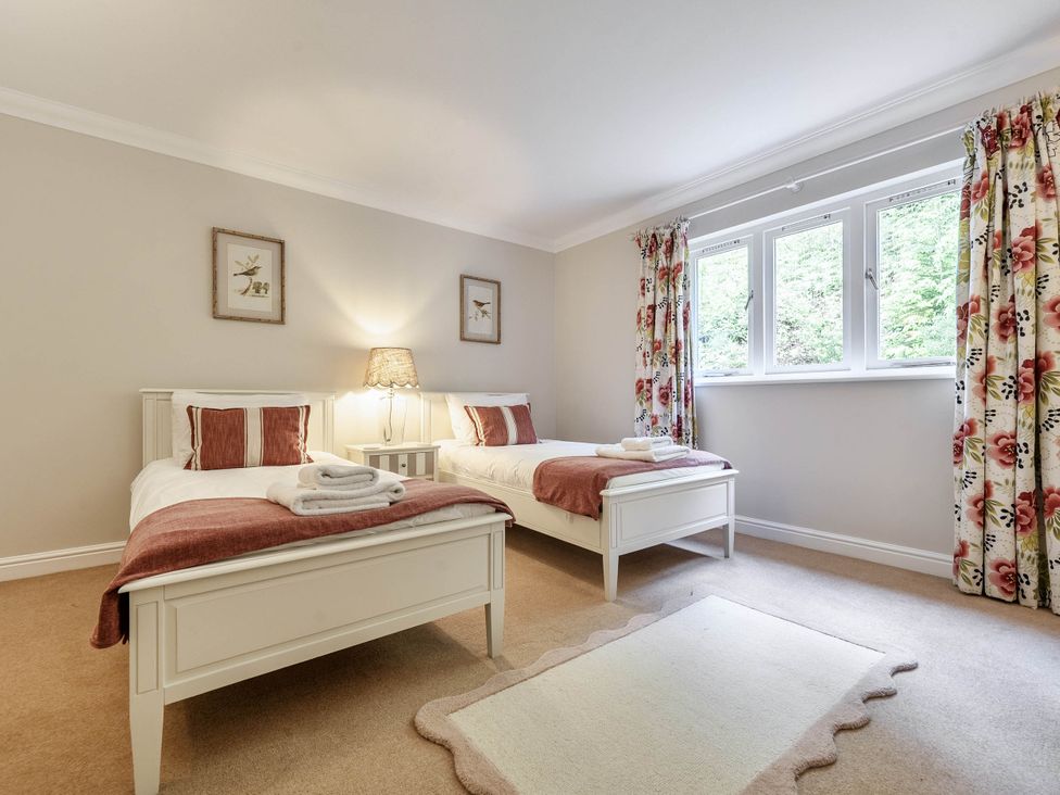 A bedroom with two beds and window at Cunsey Lodge at the Graythwaite Estate near Hawkshead