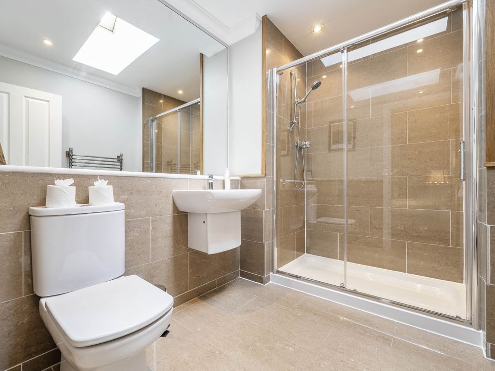A bathroom with a shower, toilet, and sink at Cunsey Lodge at the Graythwaite Estate near Hawkshead