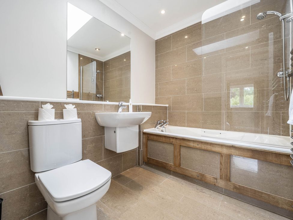 A bathroom with a sink, toilet, bathtub, and shower at Cunsey Lodge at the Graythwaite Estate near Hawkshead