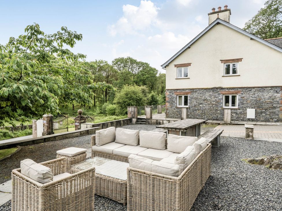 An outdoor seating area with a sofa and table at Cunsey Lodge at the Graythwaite Estate near Hawkshead