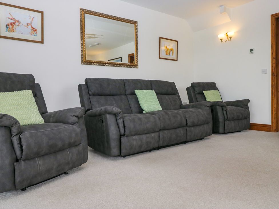 A living room with recliner sofas and a mirror at Sherriff, Troutbeck, near Keswick