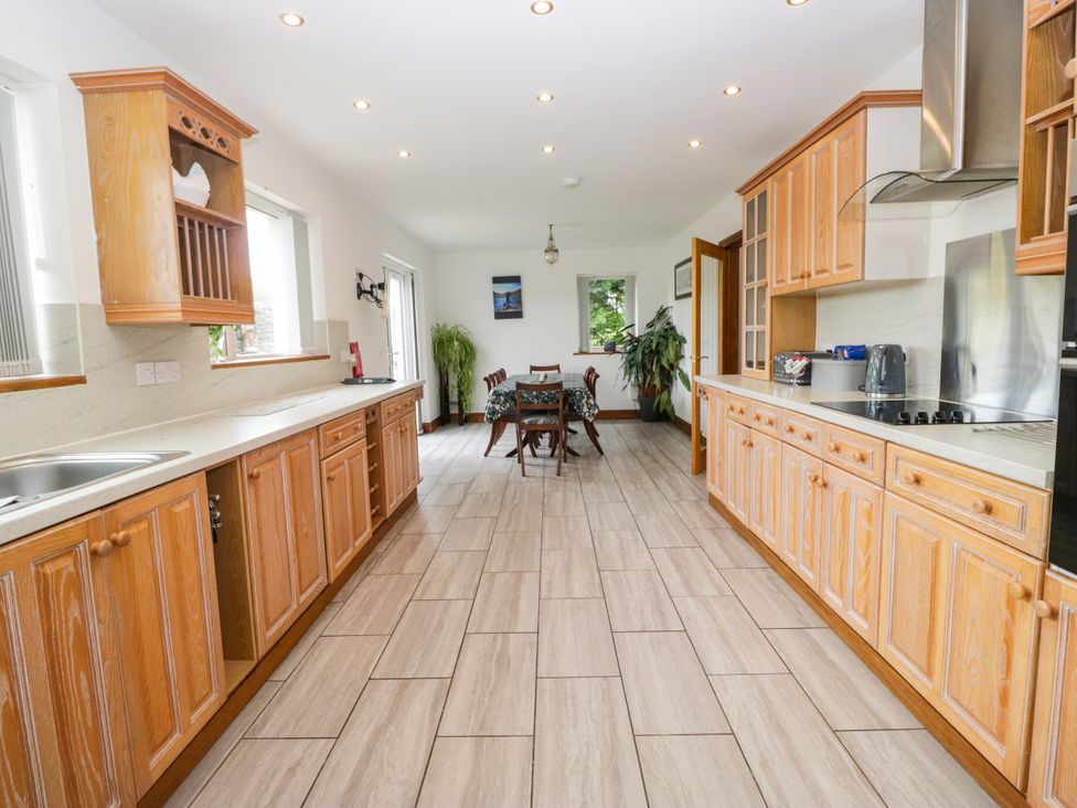 A kitchen with wooden cabinets and a dining table at Sherriff, Troutbeck, near Keswick