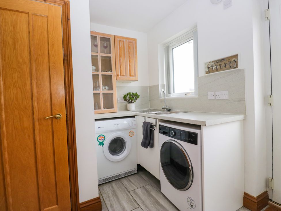 A laundry room with a washing machine and sink at Sherriff, Troutbeck, near Keswick