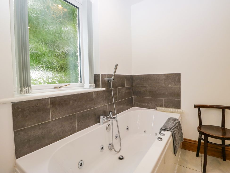 A bathroom with a bathtub and a window at Sherriff, Troutbeck, near Keswick