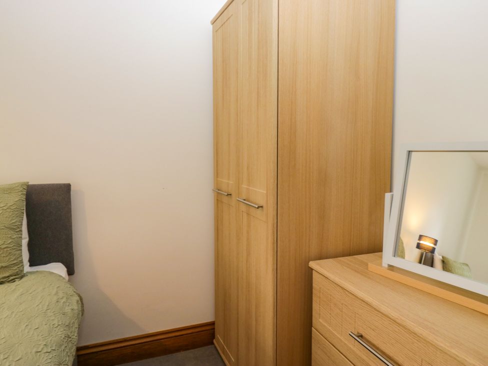 A bedroom with a wardrobe and chest of drawers at Sherriff, Troutbeck, near Keswick