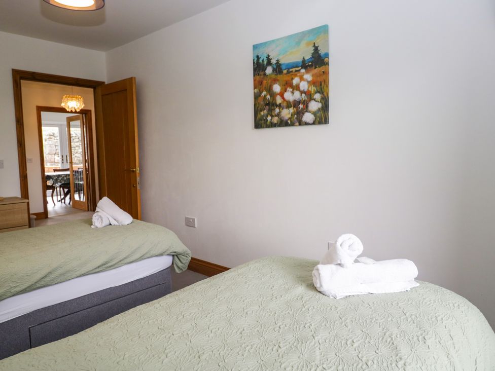 A bedroom with two beds and towels at Sherriff, Troutbeck, near Keswick
