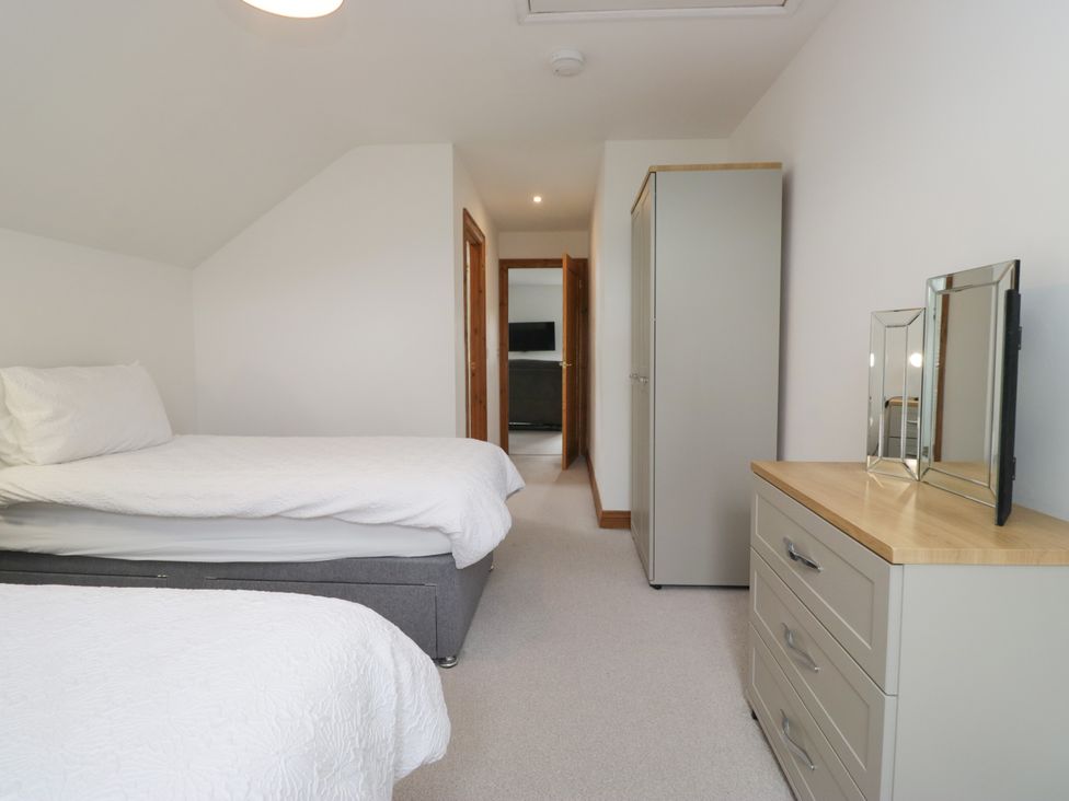 A bedroom with two beds and storage furniture at Sherriff, Troutbeck, near Keswick
