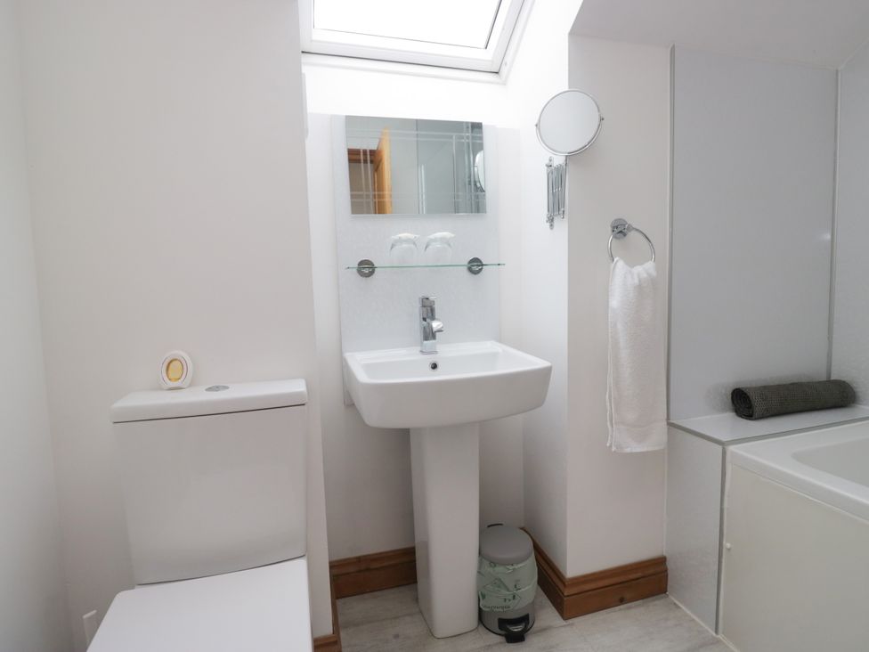 A bathroom with a toilet, wash basin, and bathtub at Sherriff, Troutbeck, near Keswick