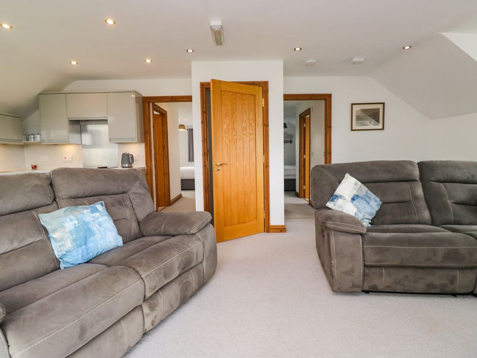 A living room with sofas and a door leading to the kitchen at Sherriff in Troutbeck, near Keswick