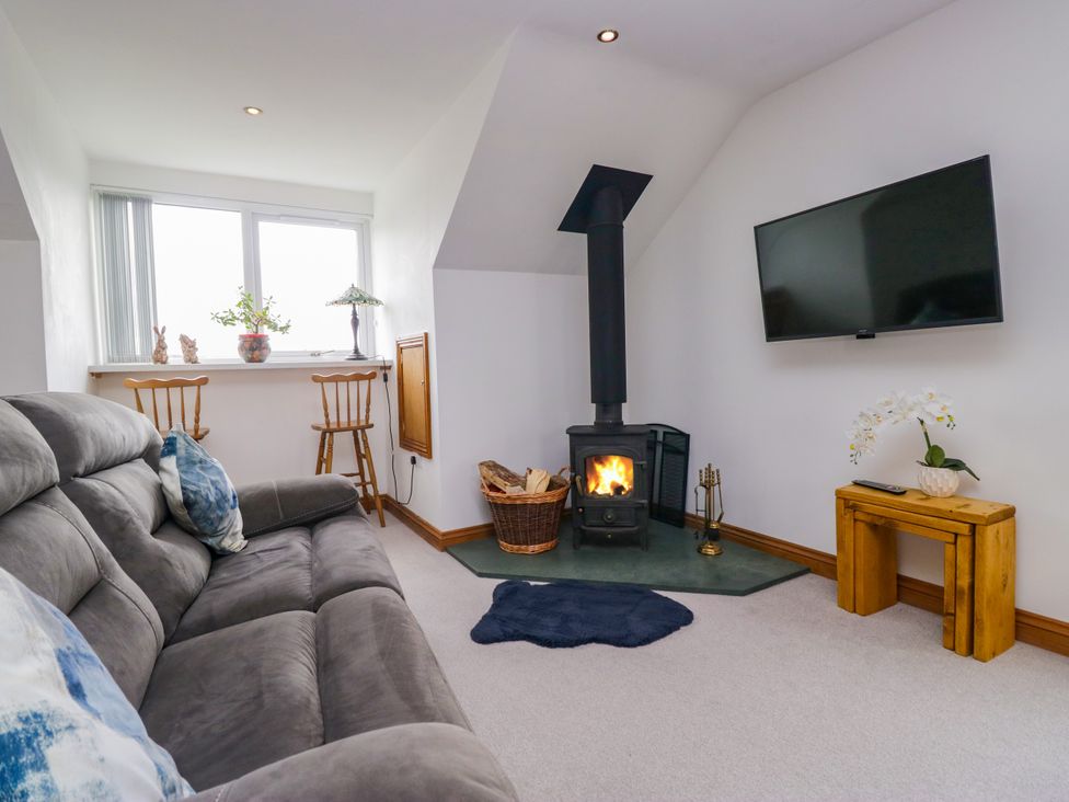 A living room with a stove and television at Sherriff, Troutbeck, near Keswick
