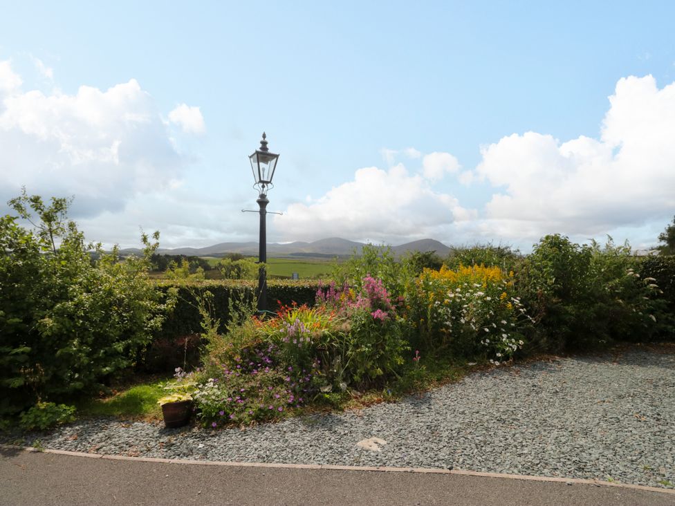 An outdoor view of a garden with flowers and a lamp post at Sherriff in Troutbeck, near Keswick