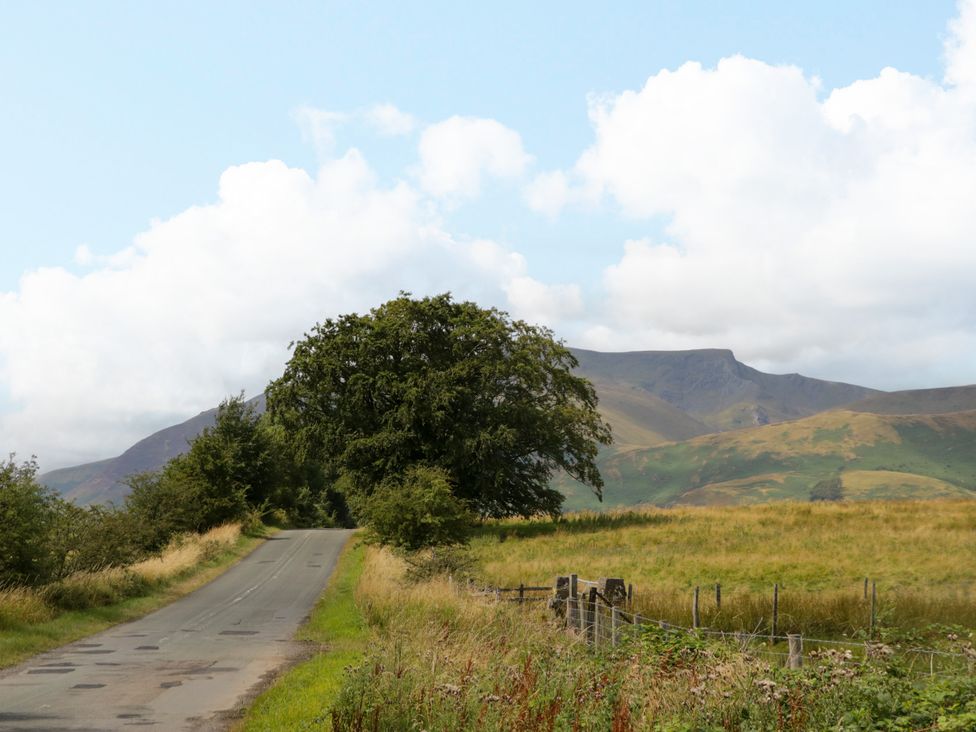 A rural scene with a road and tree near mountains at Sherriff, Troutbeck, near Keswick