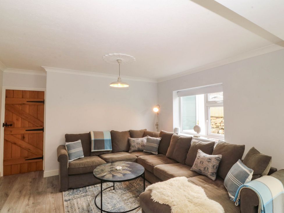 A living room with a sofa and coffee table at Afallon in Llanbedrog