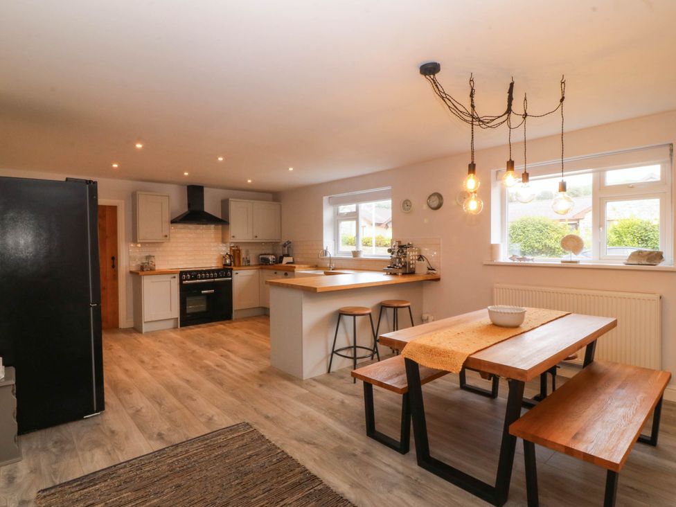A kitchen with a dining area and appliances at Afallon in Llanbedrog