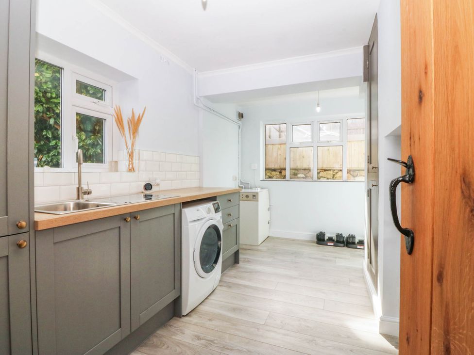 A kitchen with a washing machine and sink at Afallon in Llanbedrog