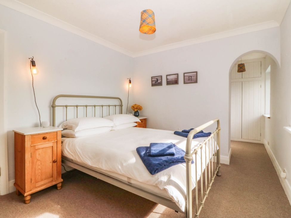 A bedroom with a bed and bedside table at Afallon in Llanbedrog