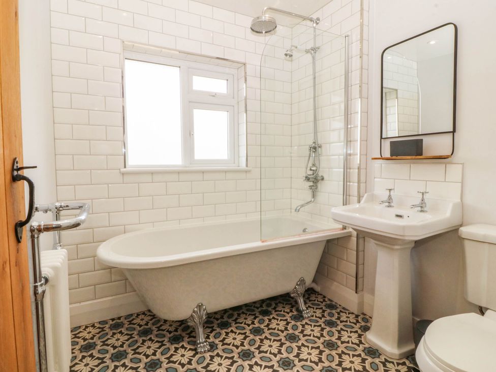 A bathroom with a bathtub and sink at Afallon in Llanbedrog