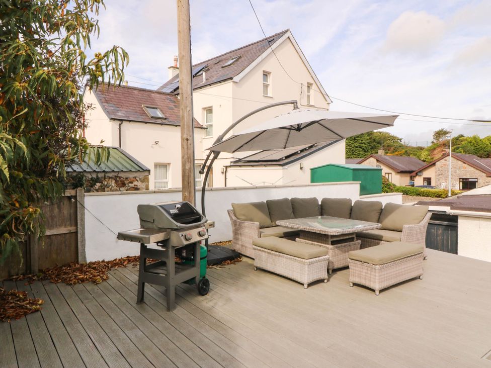 An outdoor seating area with a grill and table at Afallon in Llanbedrog