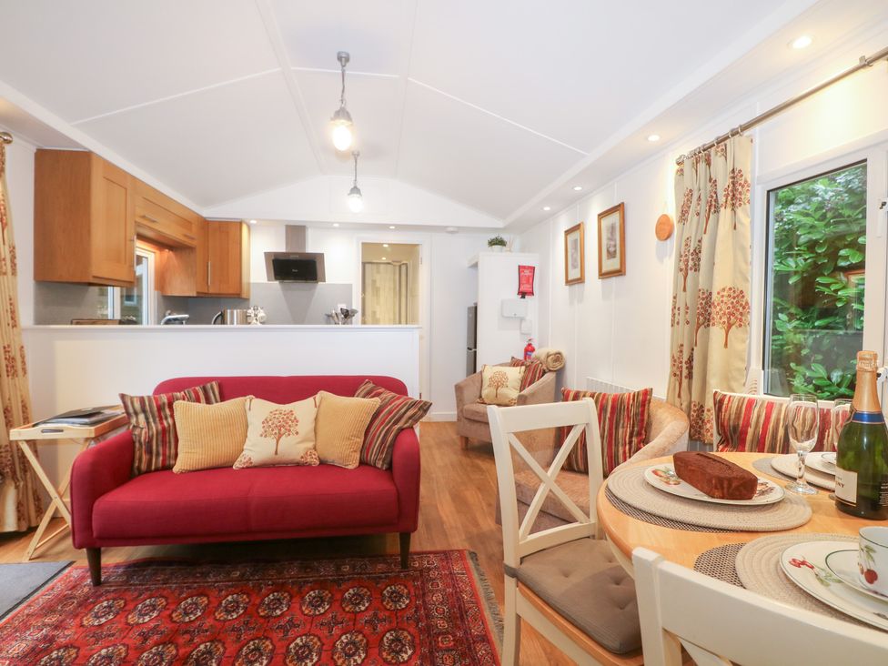 A living room with a dining area and kitchen in Orchard Lodge Bolney