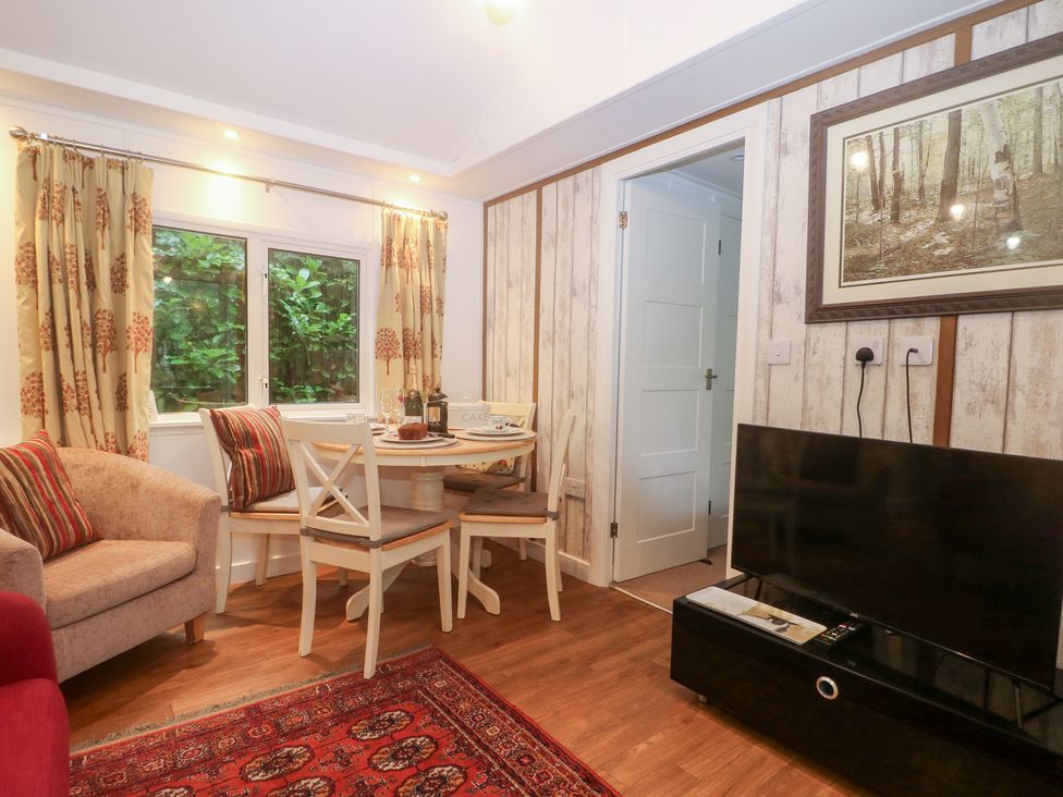 A living room with a dining table and sofa at Orchard Lodge in Bolney