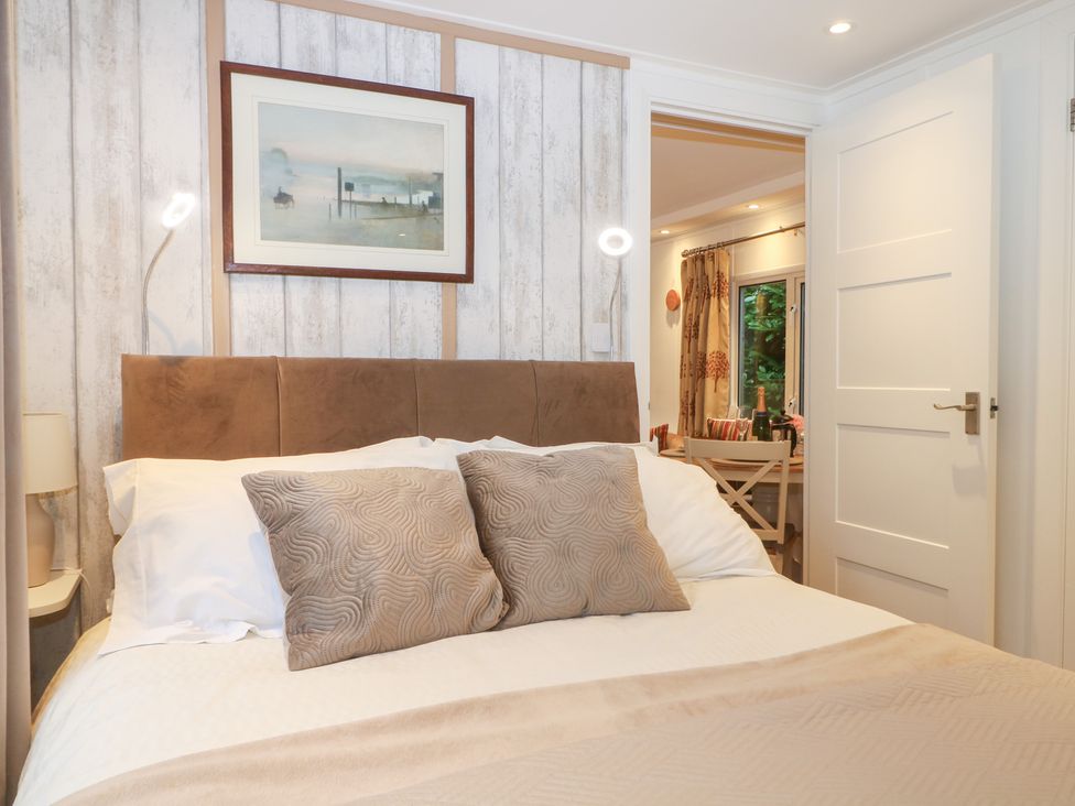 A bedroom with a bed and a painting at Orchard Lodge in Bolney