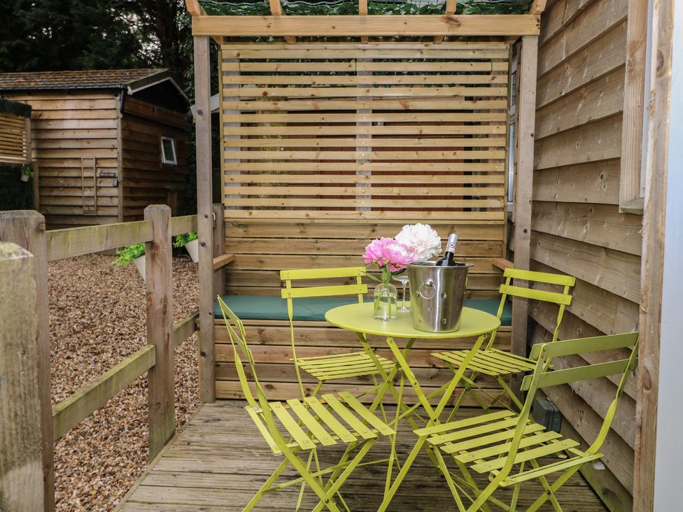 An outdoor seating area with a table and chairs at Orchard Lodge in Bolney