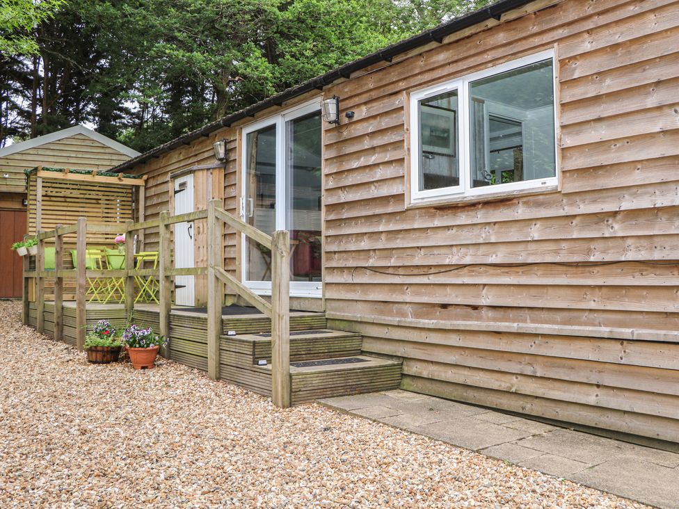 An outdoor area with steps leading to a wooden building at Orchard Lodge in Bolney
