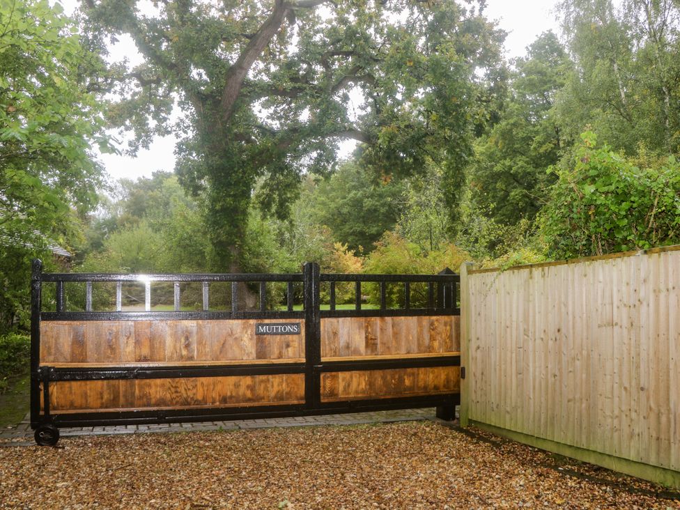A wooden gate with a sign at Muttons in Wineham near Bolney