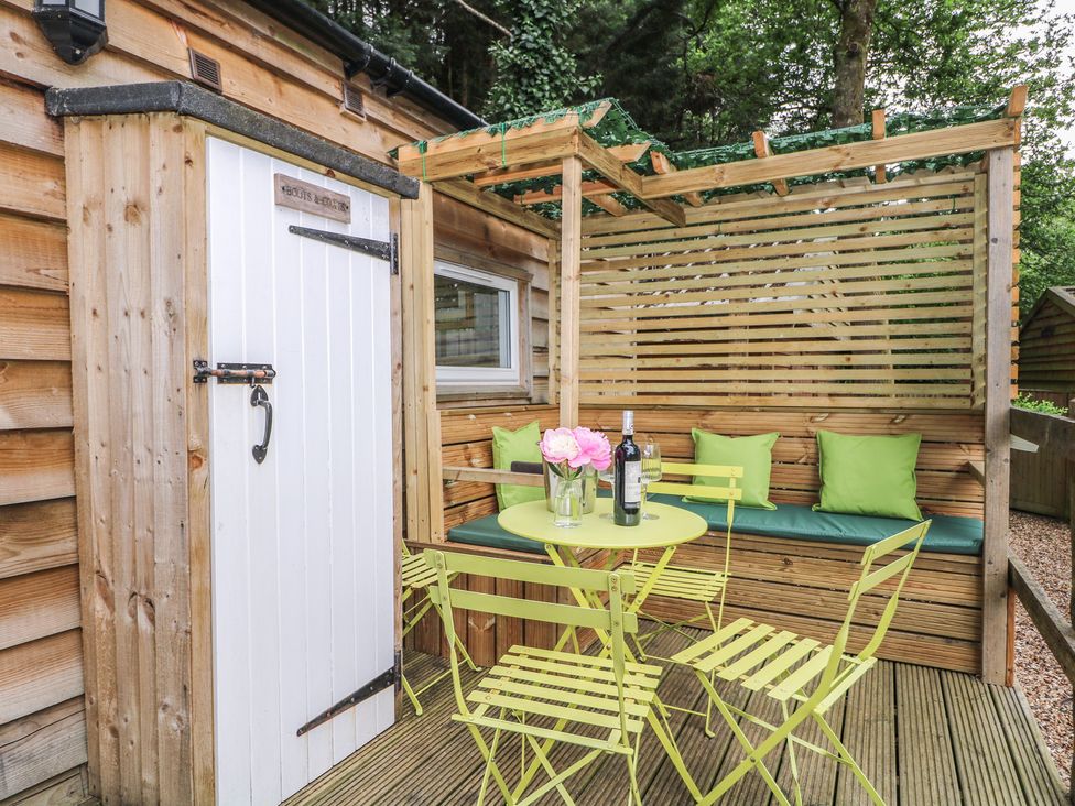 An outdoor seating area with a table and chairs at Harvest Lodge in Wineham near Bolney