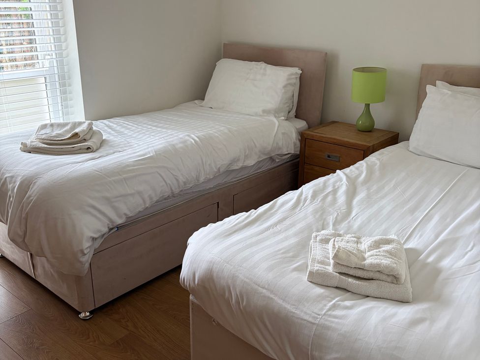A bedroom with two beds and a bedside table at Beechwood Cottage Easby near Great Ayton