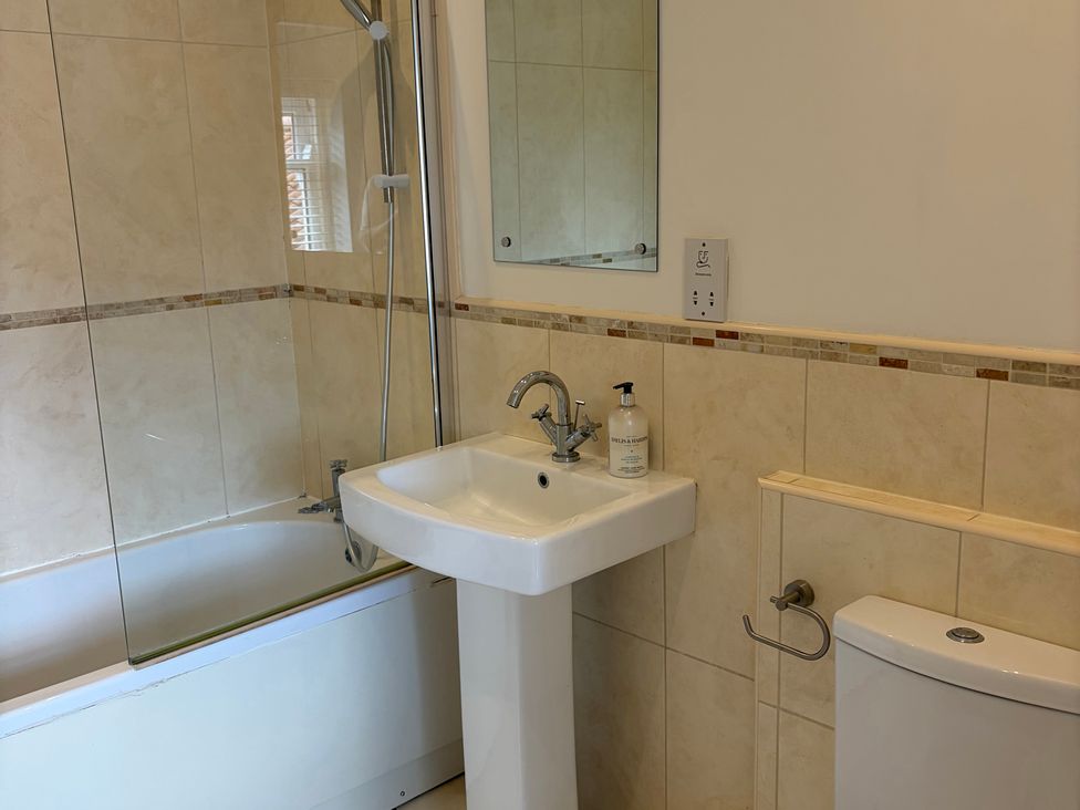 A bathroom with a bathtub, sink, and toilet at Beechwood Cottage in Easby near Great Ayton