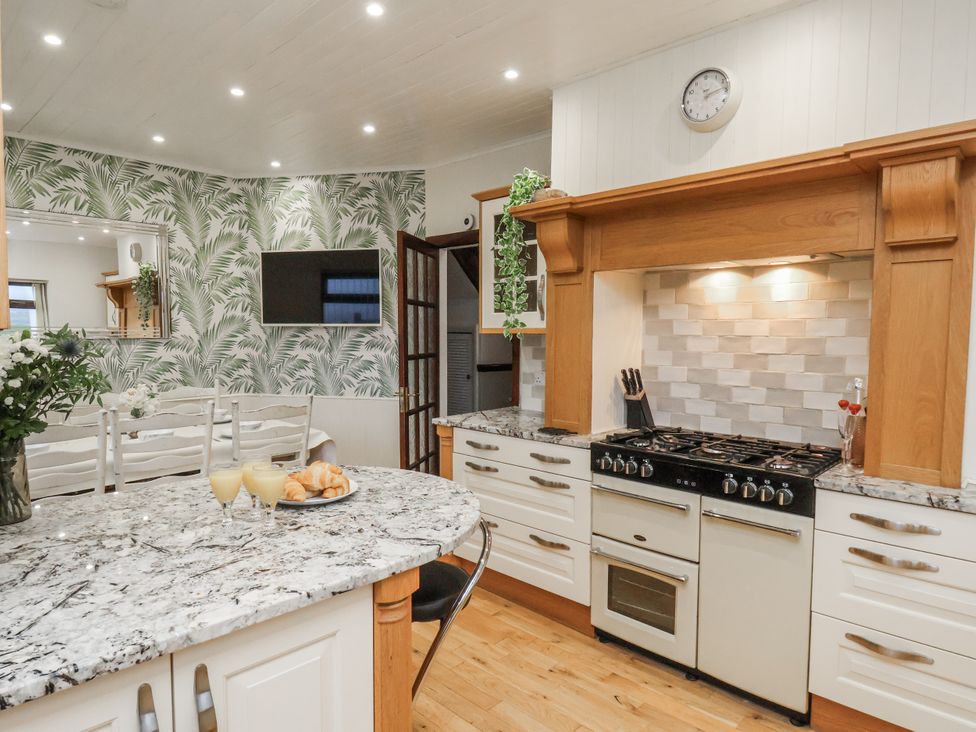 A kitchen with an oven and dining table at Beachcrest in Whitby