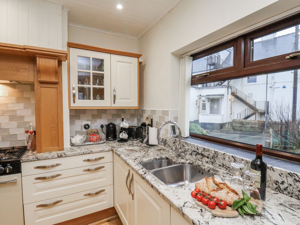 A kitchen with granite countertops and sink at Beachcrest in Whitby