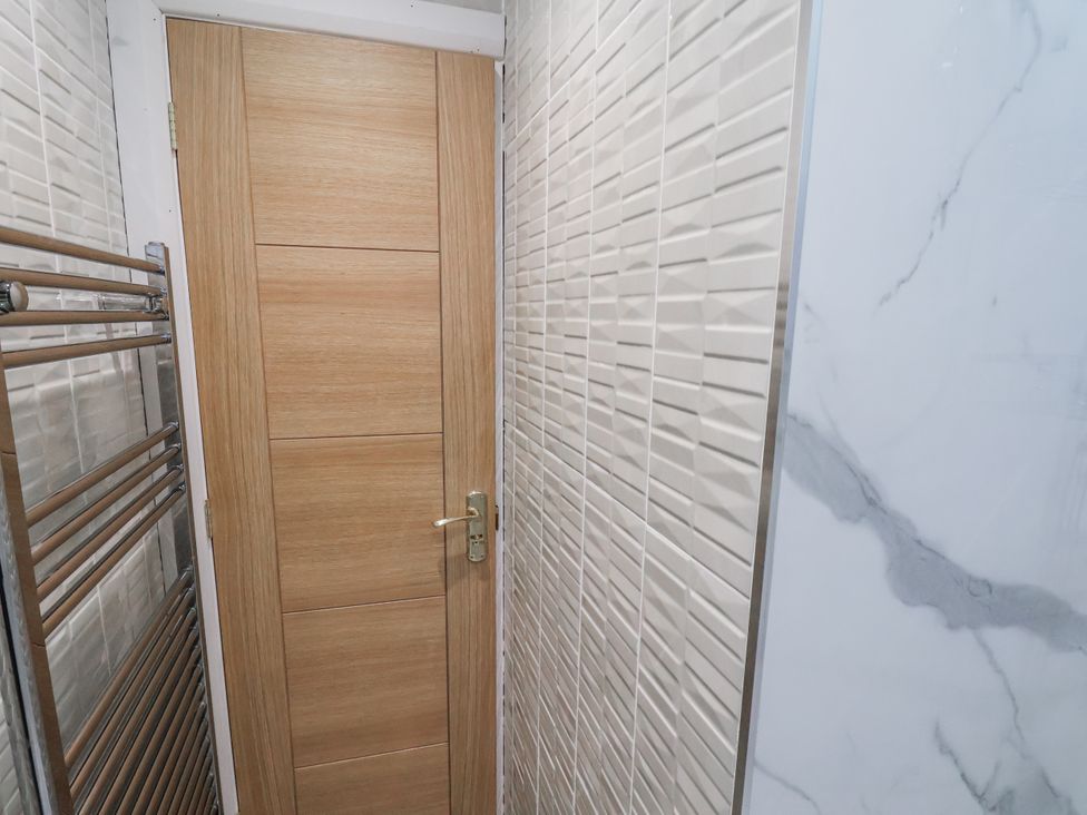 A bathroom with a door and towel radiator at Beachcrest in Whitby