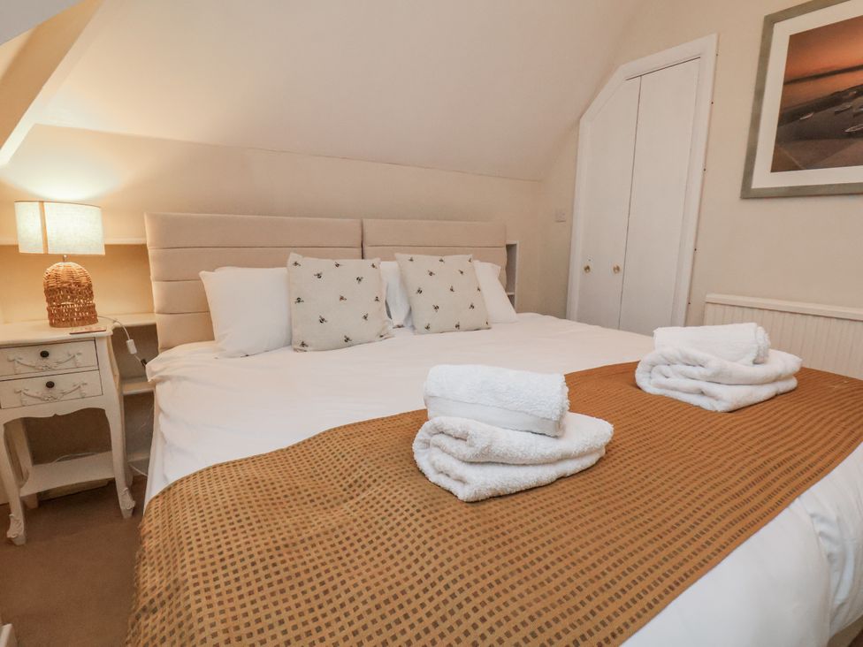 A bedroom with a large bed and bedside table at Beachcrest in Whitby