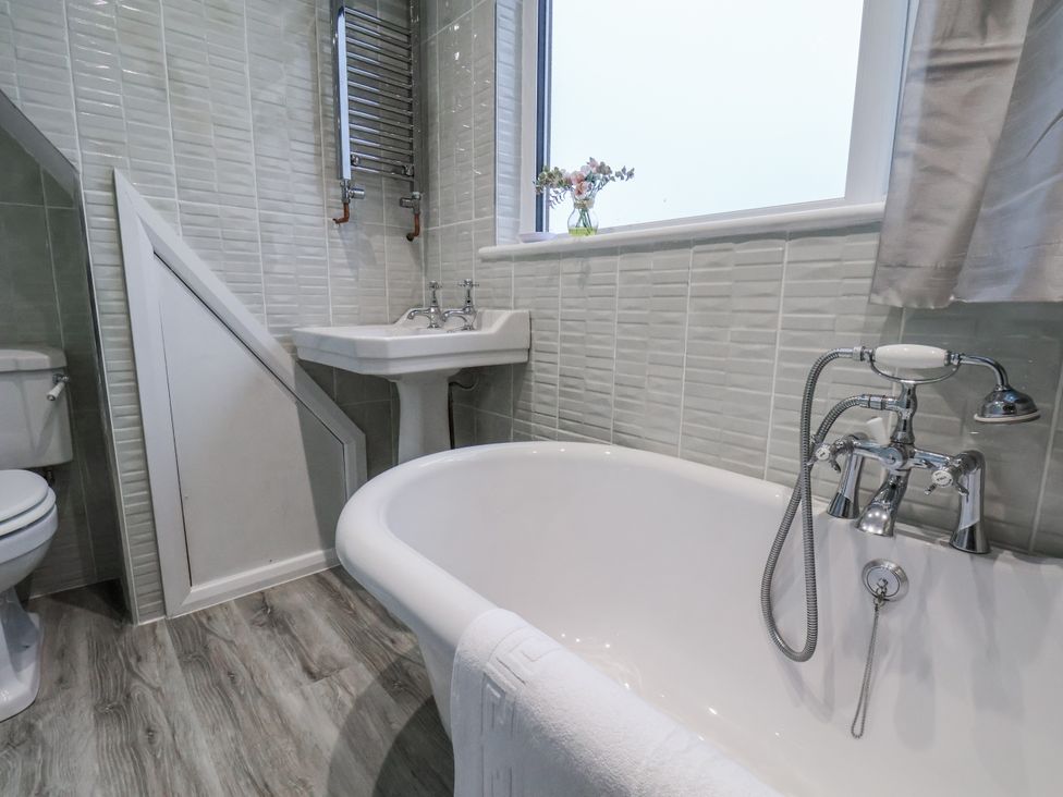 A bathroom with a bathtub, sink, and toilet at Beachcrest in Whitby